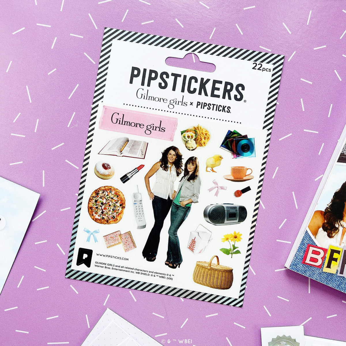A package of PIPSTICKS 'Gilmore girls' stickers, containing 22 pieces. The packaging features a black and white striped border, the PIPSTICKS brand name, and a central white panel displaying various sticker designs inspired by the 'Gilmore Girls' series, 